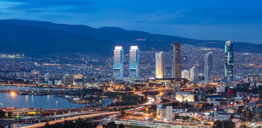 View of Izmir Turley from the sea in the afternoon, with city lights, buildings, and highways.